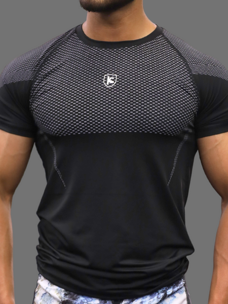 Man wearing a black athletic shirt with a logo on a gray background