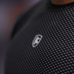 Close-up of a textured black fabric with a logo on a blurred background