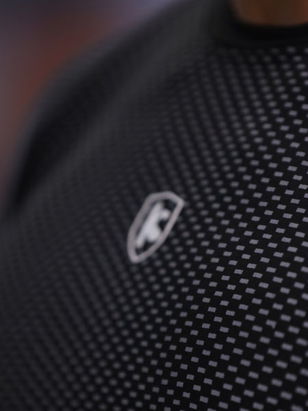 Close-up of a textured black fabric with a logo on a blurred background